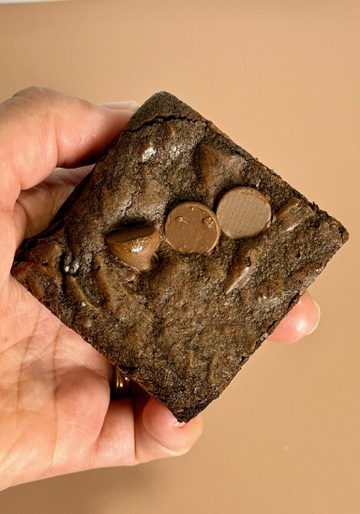 Freshly baked homestyle brownie held in hand